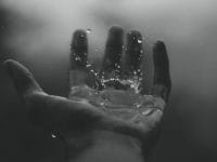 time lapse photography of water hitting left palm